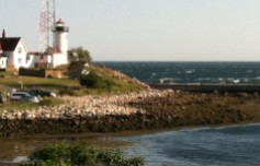 Eastern Point Light with the sea beyond as seen from the yacht club on a breezy afternoon.