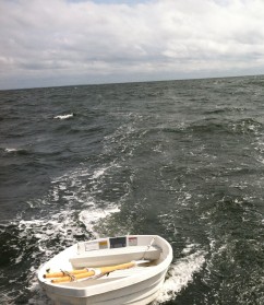 Motor-sailing along the Connecticut shore, the dinghy strains at her painter.